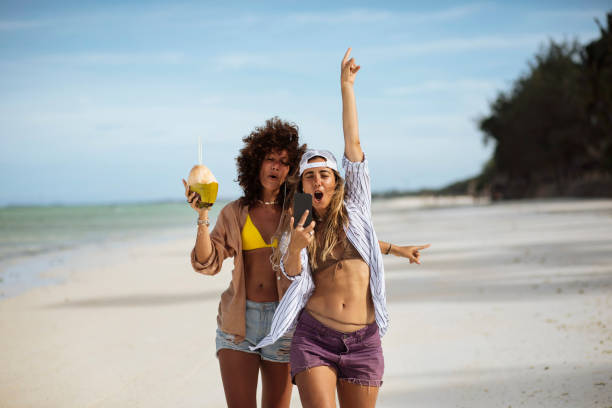 Two young women recording themselves while enjoying a summer day at the beach