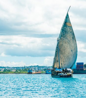 Wooden ship with timber in water of Indian ocean heading port of Stone Town. Zanzibar, Tanzania.